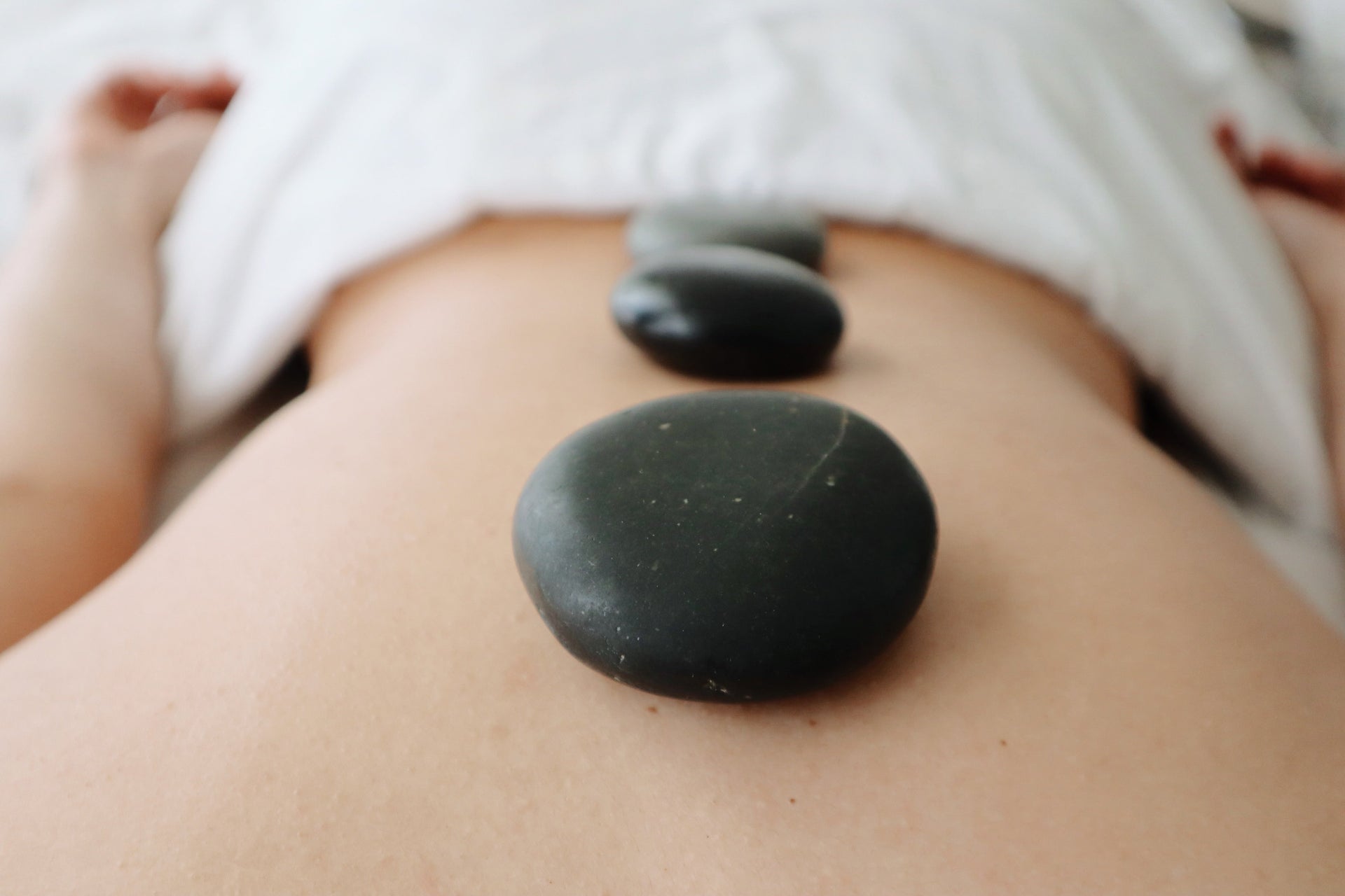 A mother receiving a relaxing hot stone massage at Bella Santé Spa for Mother’s Day