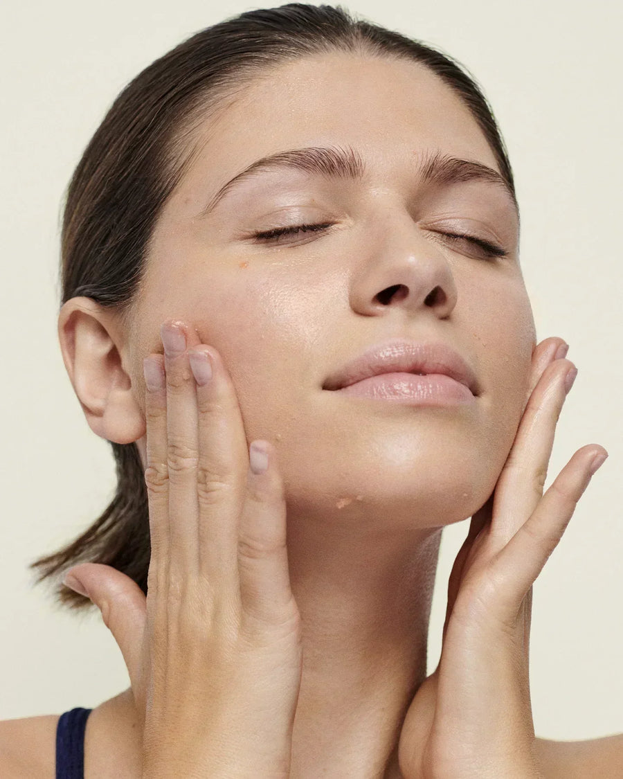 Applying vitamin C serum to face for brighter, firmer skin