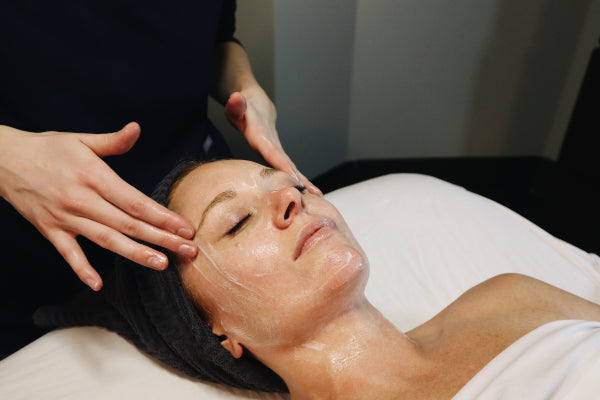 Woman relaxing and getting glowing skin during a spa facial treatment