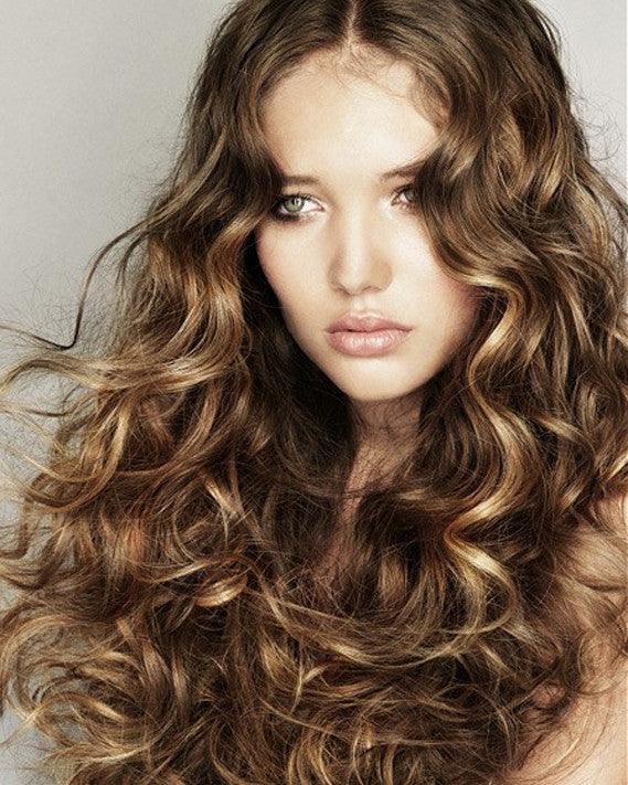 young woman with long curly hair showing healthy, defined curls after a fresh haircut