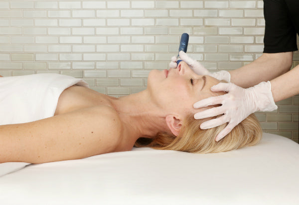 Aesthetician performing microneedling for smoother, firmer skin