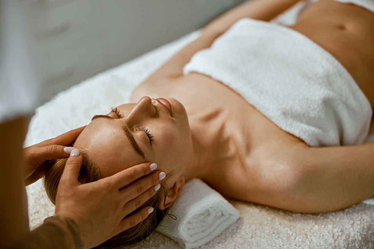 Image of a woman on a table receiving a facial treatment. Click on link to go to navigate to the Best of Boston med spa treatment menu.